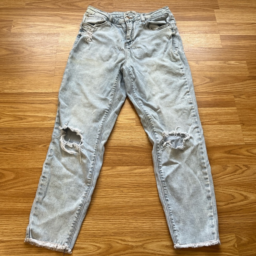 Light wash distressed boyfriend jeans with a raw hem